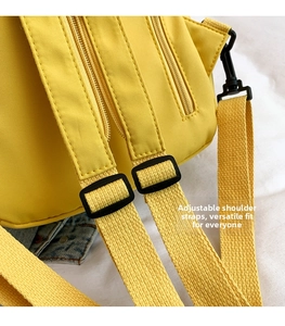 Detail of adjustable widened woven shoulder strap with black buckle on yellow backpack