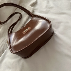 Vintage brown hobo bucket bag in glossy leather with gold logo for casual commuting