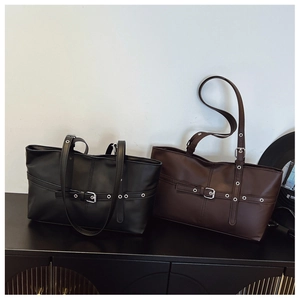 Detail of vintage tote bags with metallic buckles and eyelets in black and brown leather