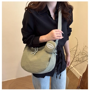 Vue détaillée du sac croissant en nylon vert clair avec sa pochette ronde amovible