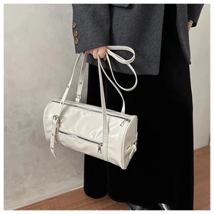 Detail view of cream Boston bag with double zippers and silver hardware on a model