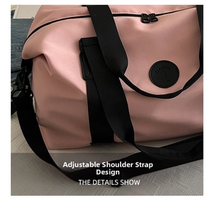 Detail view of pink oxford travel bag featuring adjustable black shoulder strap and hardware