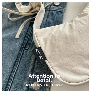 Close-up of cream nylon crescent bag showing the woven label and soft fabric texture