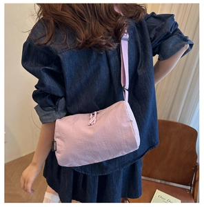 Detailed back view of a lavender nylon crossbody bag with an adjustable textile strap