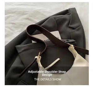 Detail showing adjustable brown shoulder strap with gold buckles on a beige handbag