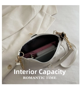 Macro view of white pleated shoulder bag interior showing spacious storage for daily items