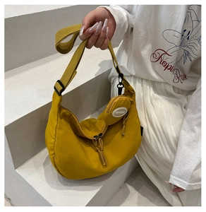 Détail du sac croissant jaune en nylon avec sangle et petit porte-monnaie rond amovible