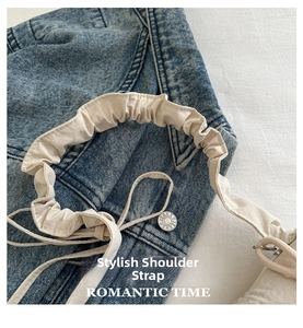 Detailed macro shot of white pleated shoulder strap with romantic branding text