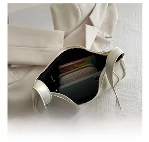 Top view of cream shoulder bag interior showing capacity for phone and wallet