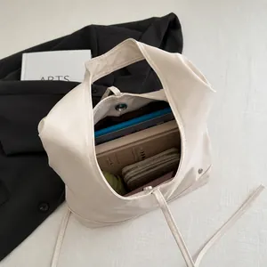 Grande borsa tote in pelle cerata avorio che mostra gli oggetti interni
