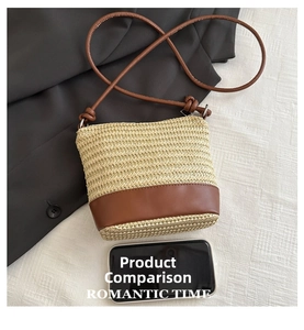 Straw woven bucket bag with brown leather straps shown beside a phone for scale