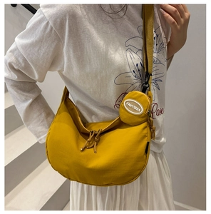 Détail du sac bandoulière demi-lune jaune avec mini porte-monnaie et bandoulière