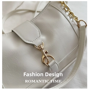 Detail of cream faux leather texture and vintage gold buckle on a chic shoulder bag