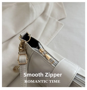 Macro shot of high-quality gold zipper closure on white PU leather underarm bag