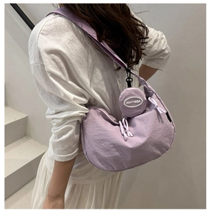 Détail macro du sac croissant en nylon lavande avec mini porte-monnaie rond et large bandoulière