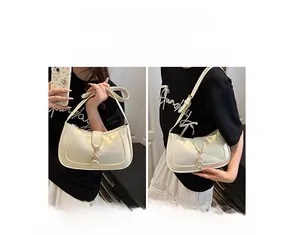 Detail of cream white half-moon underarm bag with gold buckle showing two carrying ways