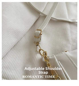 Close-up of adjustable strap with gold-tone hardware on white textured leather bag