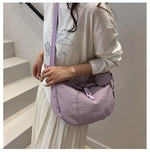 Détail du sac croissant en nylon lilas avec bandoulière et petit porte-monnaie rond