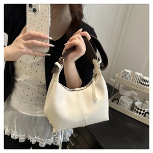Detail of cream white leather hobo bag with brown strap shown in casual mirror selfie