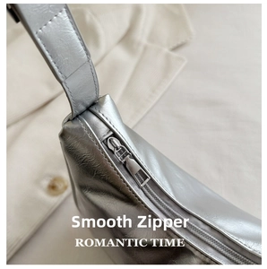 Detailed close-up of smooth silver metal zipper on vintage metallic shoulder bag