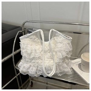 Dettaglio della borsa tote in pizzo bianco con volant a balze e tracolla minimalista