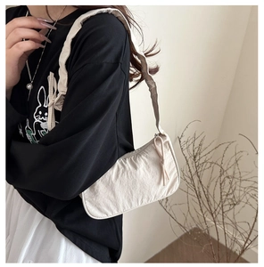 Detailed view of white nylon shoulder bag featuring vintage pleated texture and strap