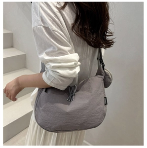Détail du sac à main en nylon plissé gris avec cordon et mini pochette ronde pour monnaie