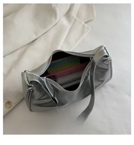 Interior view of silver metallic shoulder bag showing spacious storage capacity and zip