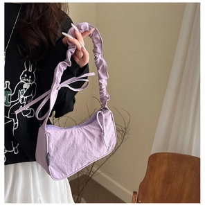 Close-up of a purple nylon underarm bag with pleated cloud strap and smooth zipper detail