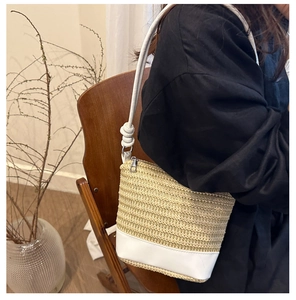 Detail of hand-woven beige crossbody bag with white leather strap and silver zipper closure