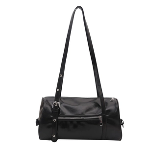 Minimalist black cylinder pillow bag with silver eyelet strap and glossy leather finish