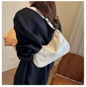 Minimalist white polished leather hobo bag worn by model for a casual urban look