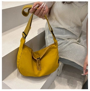 Detail of yellow nylon crescent bag with adjustable strap and double zipper closure