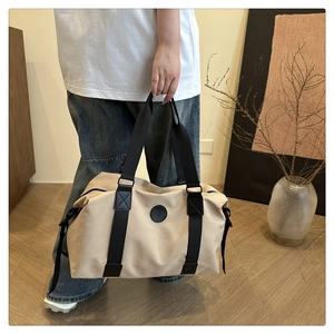 Detail of beige waterproof travel bag with high density nylon straps and round logo