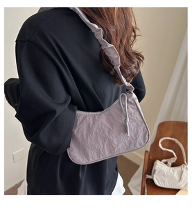Detail of lavender nylon shoulder bag with ruffled strap and knotted bow decoration