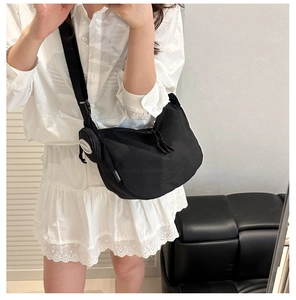 Détail du sac croissant en nylon noir avec double fermeture éclair et petit porte-monnaie