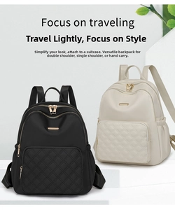 Detail of quilted nylon backpacks in black and beige showing luggage strap and gold zippers