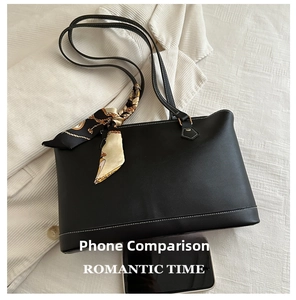 Close-up of black tote bag texture with white stitching and decorative silk scarf