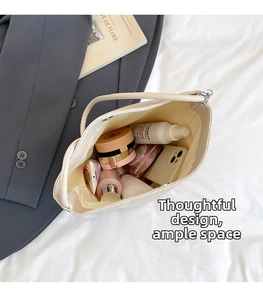 Spacious interior of beige pebbled leather bucket bag showing everyday makeup essentials