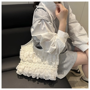 Detail showing the layered lace texture and delicate ruffles of the white tote bag