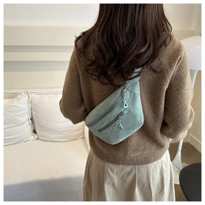 Detailed close-up of mint green corduroy crossbody bag with triangular zipper puller