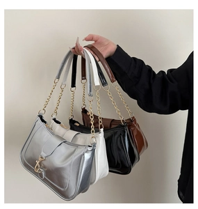 Close-up of four shoulder bags in silver, white, black, and brown with chain straps