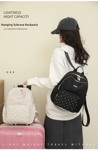 Detail of multi-compartment travel backpack with rivet decor and luggage strap function
