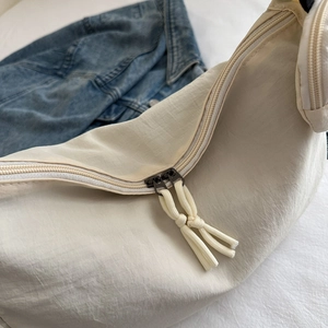Sac bandoulière minimaliste blanc crème en nylon texturé avec détails zippés