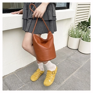 Close-up of brown litchi pattern leather bucket bag with metallic chain and long strap