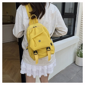 Detail view of mini yellow nylon sling bag showing dual zippers and waterproof texture