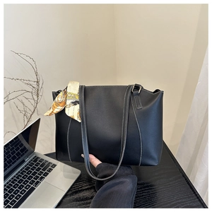 Detail of black tote bag with white contrast stitching and orange printed silk scarf
