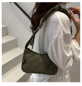 Detail of olive green crescent hobo bag with ruffled shoulder strap and woven label