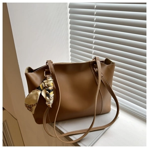 Brown tote bag detail with decorative vintage chain pattern silk scarf on handle