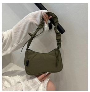 Detail of army green nylon shoulder bag featuring a unique scrunchie style strap